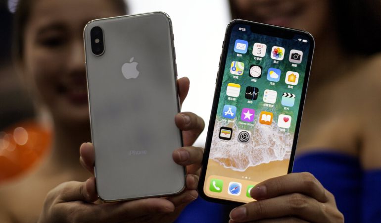 Dos mujeres sostienen dos ejemplares del nuevo iPhone X en una tienda de Apple en Taipei, Taiwán Dos mujeres sostienen dos ejemplares del nuevo iPhone X en una tienda de Apple en Taipei, Taiwán