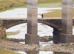 GRAF3938. PORTOMARÍN (LUGO), 22/11/2017.- Un hombre atraviesa el antiguo puente romano que cruzaba el río Miño en el embalse de Belesar. El Miño es el río más grande de Galicia, ya su paso por Portomarín (Lugo), la reserva hidráulica se encuentra al 37% de su capacidad total, un registro solo superado a peor durante el periodo de sequía comprendido entre 1992 y 1995. EFE/ Eliseo Trigo