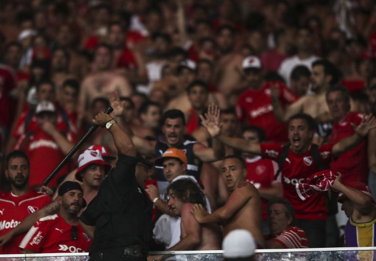 Un policía brasileño se enfrenta a aficionados de Independiente, en la final de la Copa Sudamericana, en Maracaná Un policía brasileño se enfrenta a aficionados de Independiente, en la final de la Copa Sudamericana, en Maracaná