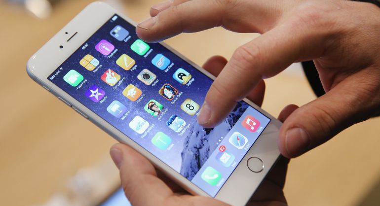 Un hombre interactúa con un iPhone 6. Un hombre interactúa con un iPhone 6.