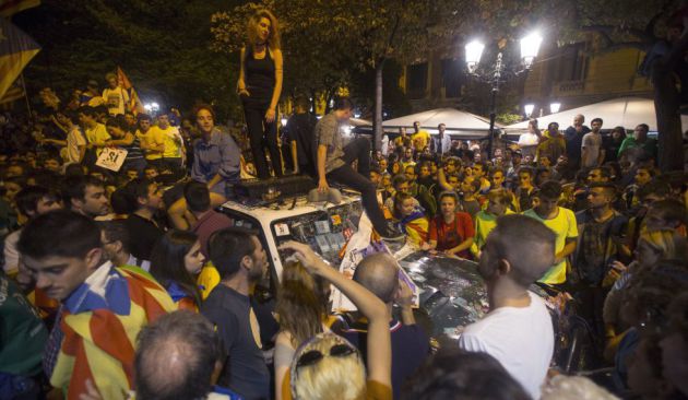 Gente subida encima de un coche destrozado de la Guardia Civil Gente subida encima de un coche destrozado de la Guardia Civil
