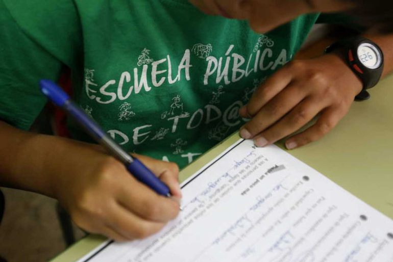 Un alumno del Colegio Joaquín Costa de Madrid rellena una ficha con la camiseta a favor de la escuela pública Un alumno del Colegio Joaquín Costa de Madrid rellena una ficha con la camiseta a favor de la escuela pública