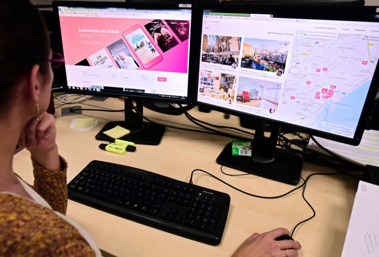 Una mujer consulta los pisos turísticos disponisble sen Airbnb Una mujer consulta los pisos turísticos disponisble sen Airbnb