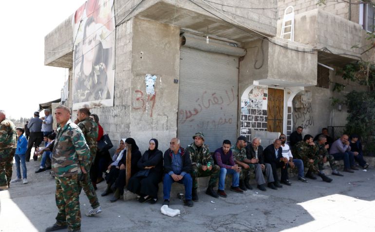 Soldados permanecen junto a familiares de personas supuestamente detenidas por combatientes del Ejército del Islam durante la evacuación de combatientes y familiares de dicho ejército desde Duma Soldados permanecen junto a familiares de personas supuestamente detenidas por combatientes del Ejército del Islam durante la evacuación de combatientes y familiares de dicho ejército desde Duma