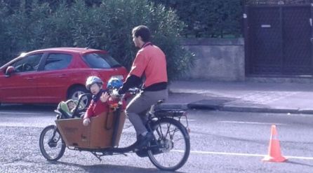 Una bicicleta cargo con tres menores. Una bicicleta cargo con tres menores.