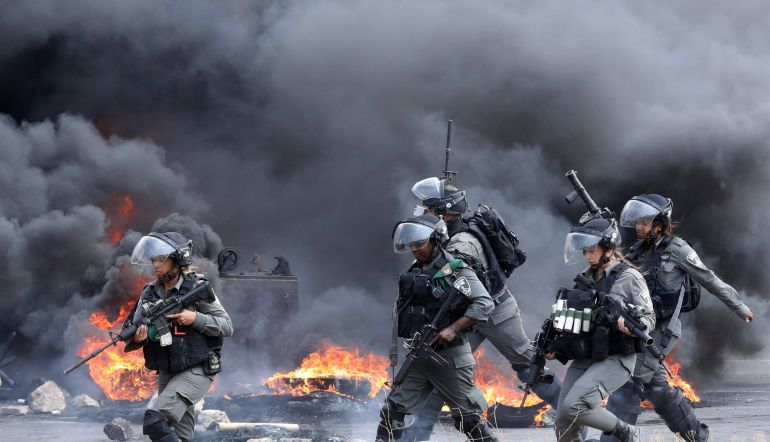 Solados israelíes persiguen a varios manifestantes palestinos durante una protesta en el puesto de control de Huwwara, cerca de la ciudad cisjordana de Nablús (Palestina) Solados israelíes persiguen a varios manifestantes palestinos durante una protesta en el puesto de control de Huwwara, cerca de la ciudad cisjordana de Nablús (Palestina)