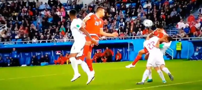 Dos jugadores suizos tumban a Mitrovic dentro del área Dos jugadores suizos tumban a Mitrovic dentro del área