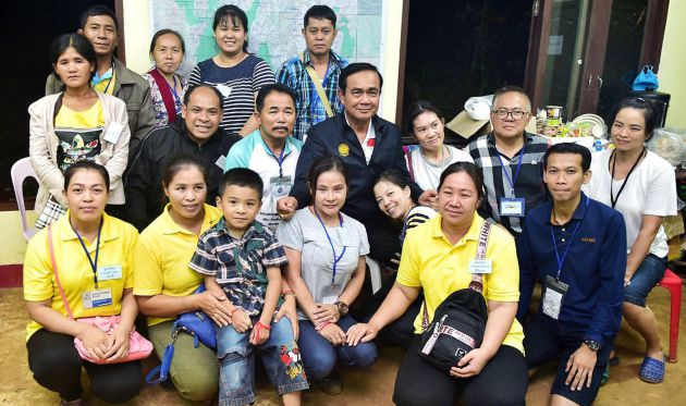 El primer ministro tailandés, Prayut Chan-o-cha, posa junto a familiares de los jugadores de fútbol atrapados en una cueva de Tham Luang. El primer ministro tailandés, Prayut Chan-o-cha, posa junto a familiares de los jugadores de fútbol atrapados en una cueva de Tham Luang.