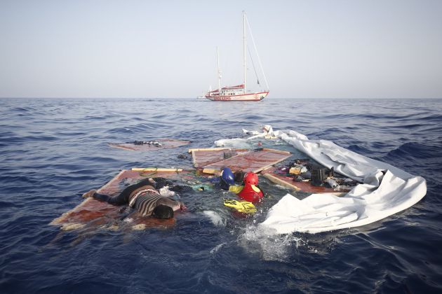 Los cuerpos de los inmigrantes sobre la barcaza destruida Los cuerpos de los inmigrantes sobre la barcaza destruida