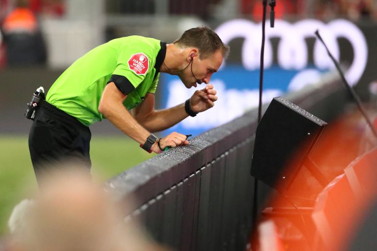 Un árbitro revisa una jugada en un partido de la Bundesliga. Un árbitro revisa una jugada en un partido de la Bundesliga.