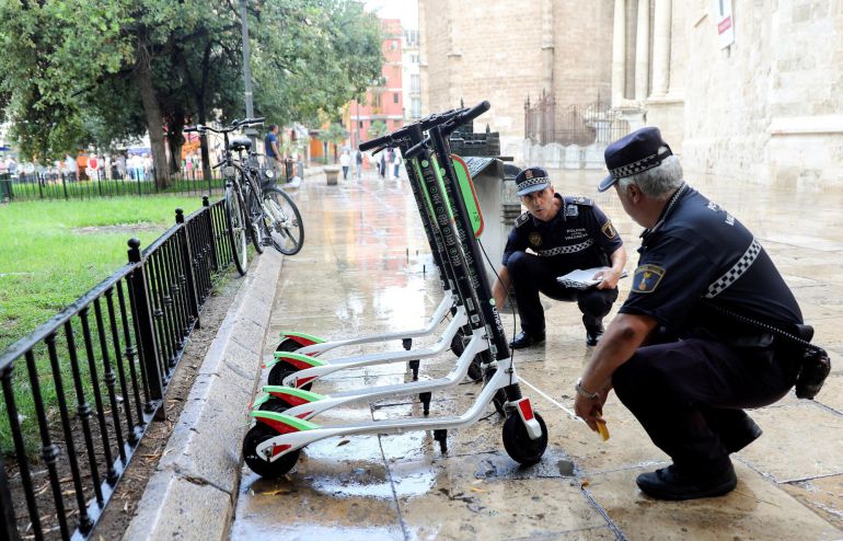 Unos agentes de la Policía Local trabajan en la retirada de los patinetes eléctricos de alquiler de la empresa Lime en Valencia Unos agentes de la Policía Local trabajan en la retirada de los patinetes eléctricos de alquiler de la empresa Lime en Valencia