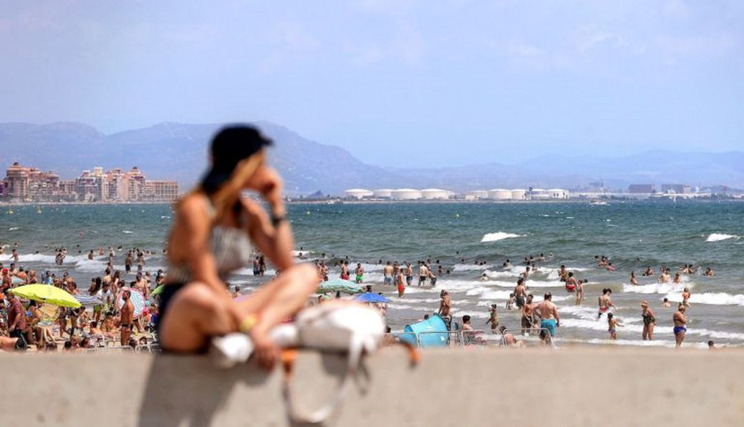Una joven observa las repletas playas de Las Arenas y La Malvarrosa de València Una joven observa las repletas playas de Las Arenas y La Malvarrosa de València