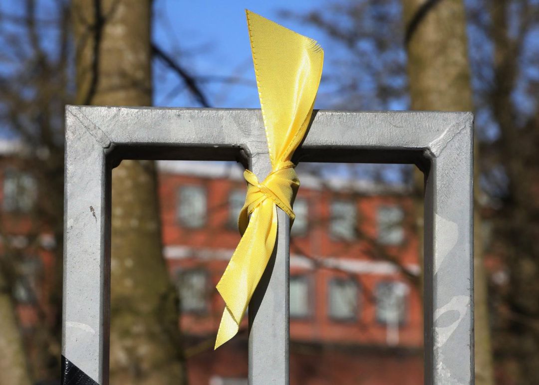 Un lazo amarillo atado en una verja Un lazo amarillo atado en una verja