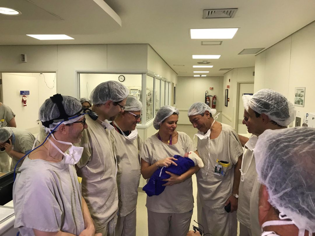 El equipo médico mira al bebé recién nacido. El equipo médico mira al bebé recién nacido.