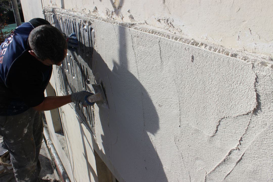 Trabajos de un operario para cubrir una placa con simbologÃ­a franquista en un edificio de Irun. 
