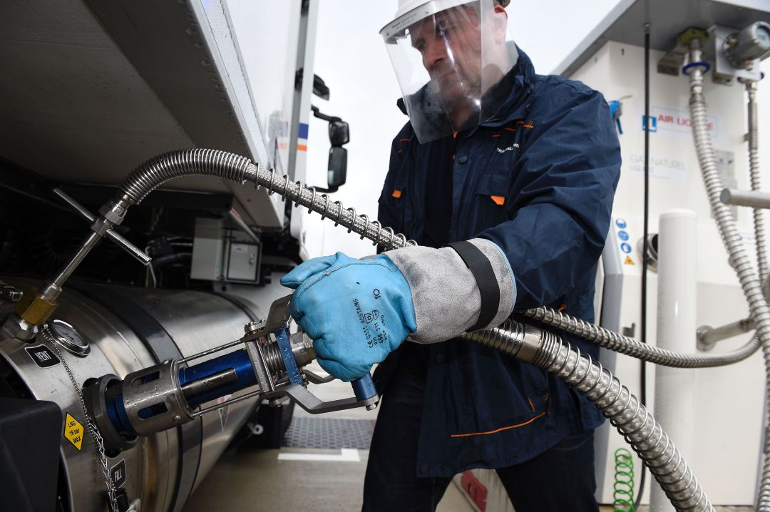 Un trabajador llena un camión con gas natural licuado en la gasolinera Un trabajador llena un camión con gas natural licuado en la gasolinera