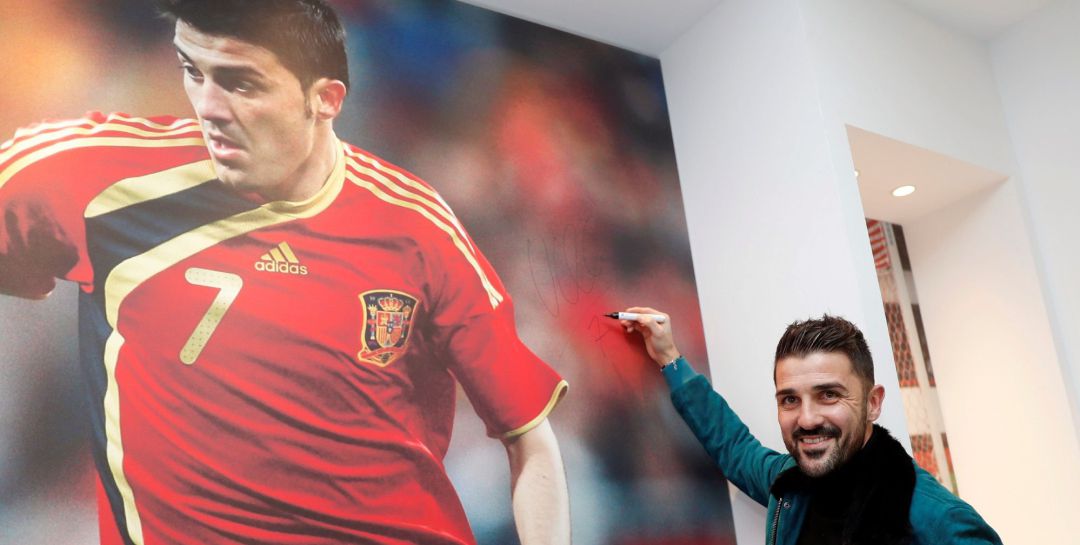 Villa posa con una imagen suya jugando un partido de la Selección Villa posa con una imagen suya jugando un partido de la Selección