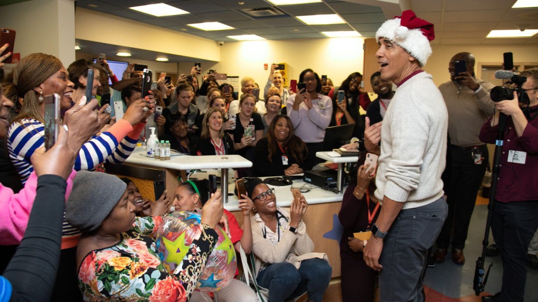 Obama entrega regalos a niños enfermos vestido con gorro y saco de Papa Noel