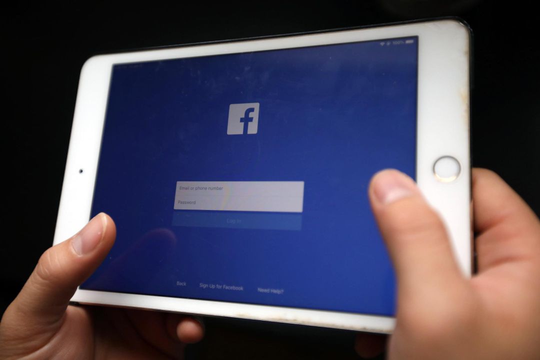 Una persona sostiene un dispositivo electrónico en la que aparece la página de inicio de una ed social. Una persona sostiene un dispositivo electrónico en la que aparece la página de inicio de una ed social.