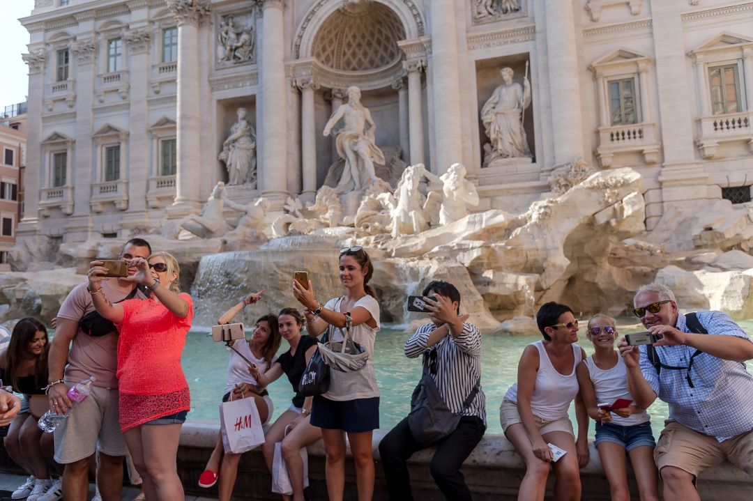 Un grupo de turistas se hace fotografías en la Fontana de Trevi Un grupo de turistas se hace fotografías en la Fontana de Trevi