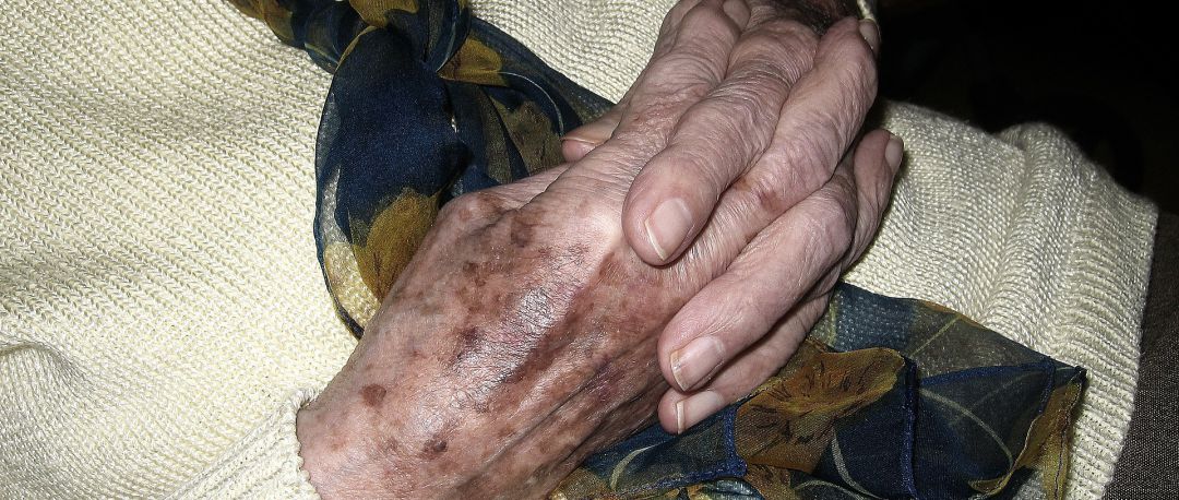 Una anciana entrelaza sus manos Una anciana entrelaza sus manos