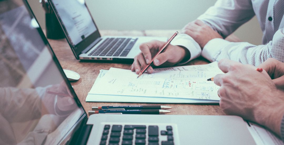 Dos personas analizan las cuentas de una empresa. Dos personas analizan las cuentas de una empresa.