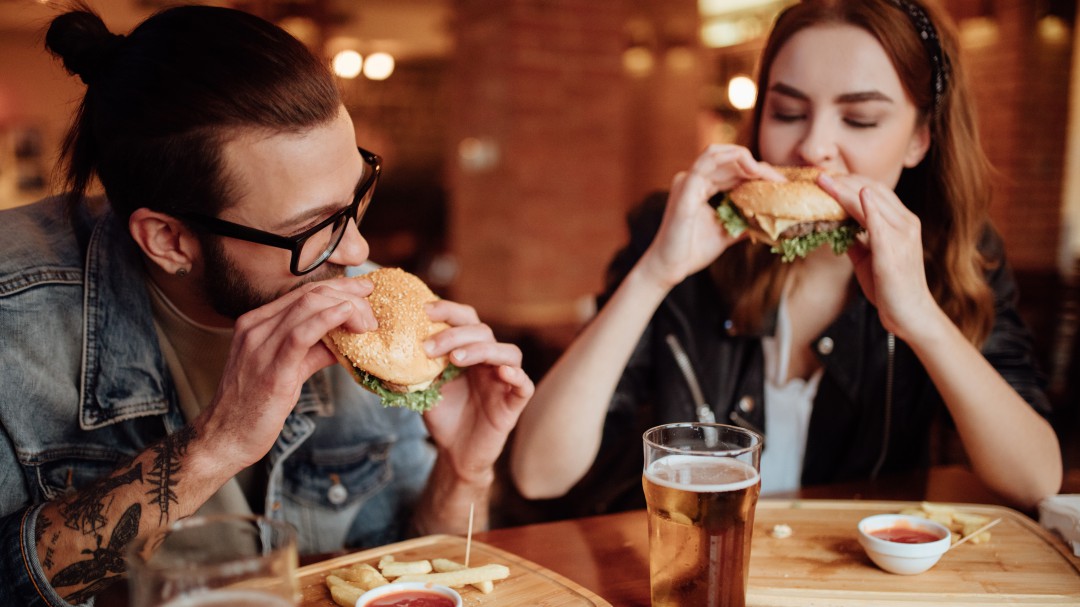Sólo dos jóvenes comiendo hamburguesas