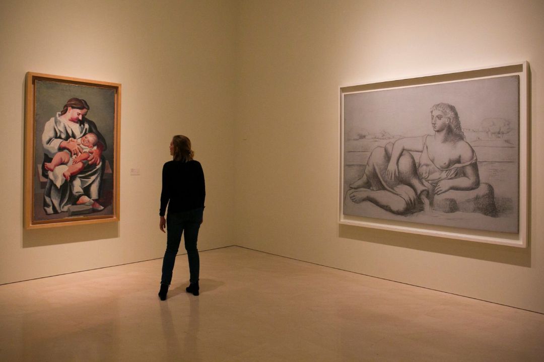 Una mujer se sitúa entre dos cuadros que forman parte de la exposición temporal "Olga Picasso" Una mujer se sitúa entre dos cuadros que forman parte de la exposición temporal "Olga Picasso"