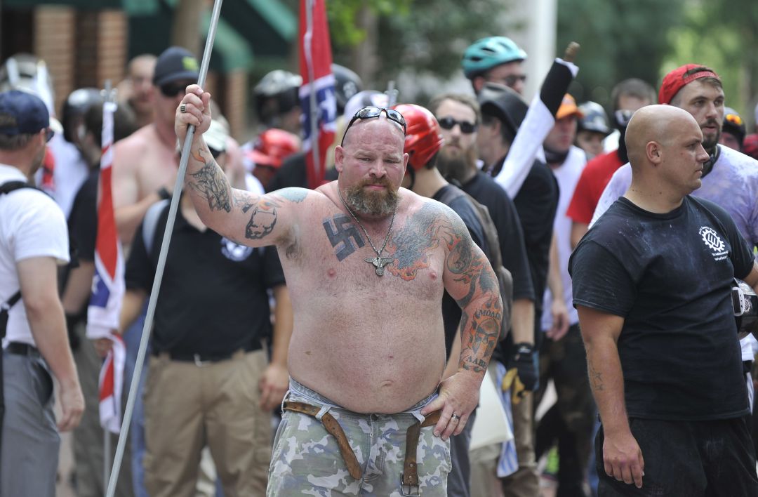 Un supremacista blanco con la hesvástica tatuada en el pecho durante la manifestación del 12 de agosto de 2017 en la que la joven Heather Heyer falleció atropellada por James Fields.
Un supremacista blanco con la hesvástica tatuada en el pecho durante la manifestación del 12 de agosto de 2017 en la que la joven Heather Heyer falleció atropellada por James Fields.