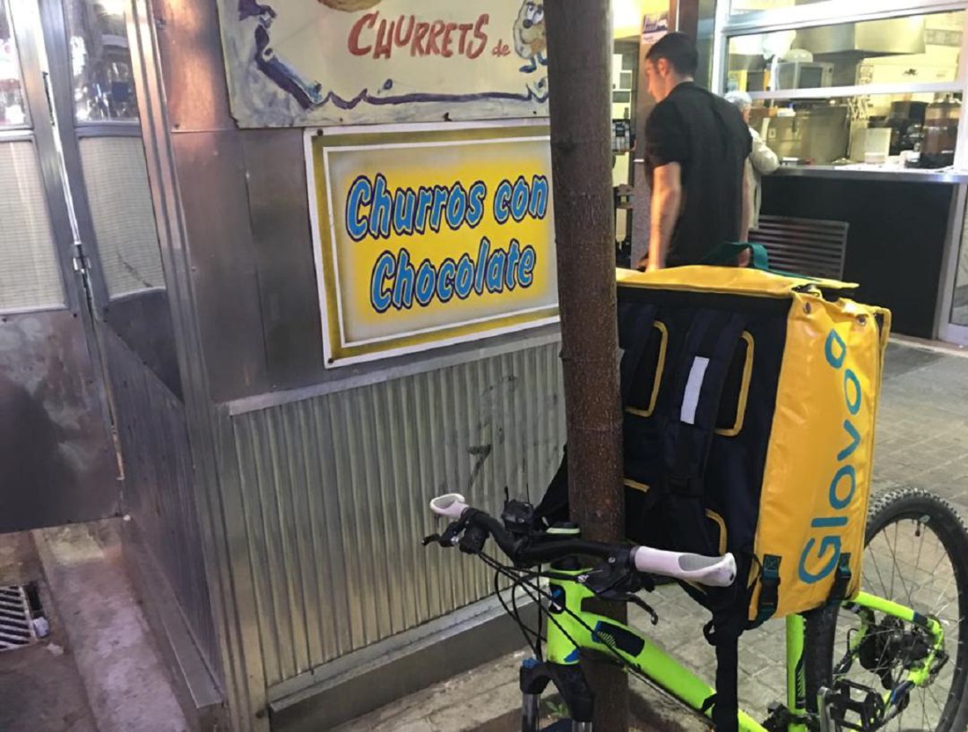 Trabajador de Glovo preparando un envío de churros Trabajador de Glovo preparando un envío de churros