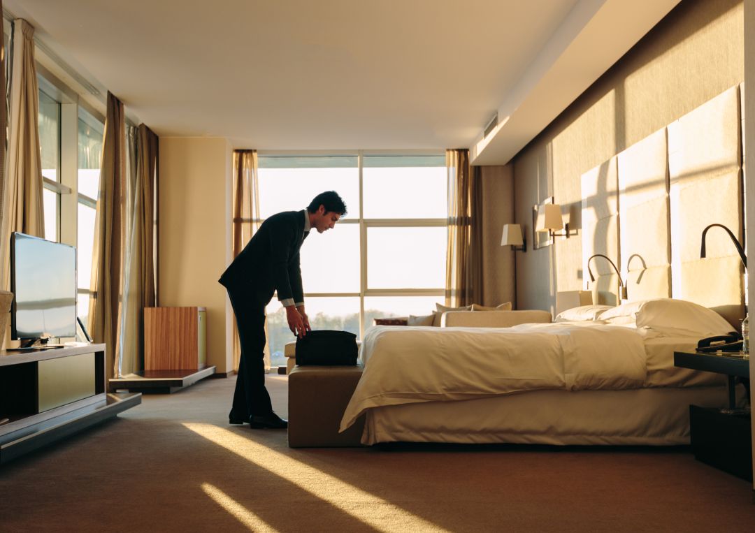 Un hombre hace su maleta en una habitación de hotel. Un hombre hace su maleta en una habitación de hotel.