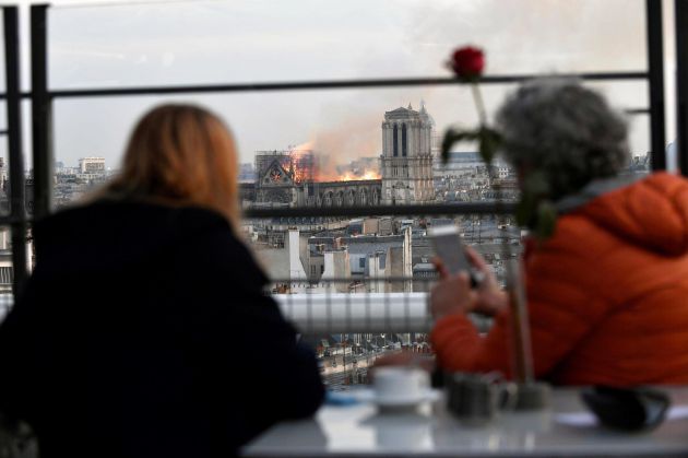 Personas observan un incendio en la catedral de Notre Dame este lunes en París, Francia Personas observan un incendio en la catedral de Notre Dame este lunes en París, Francia