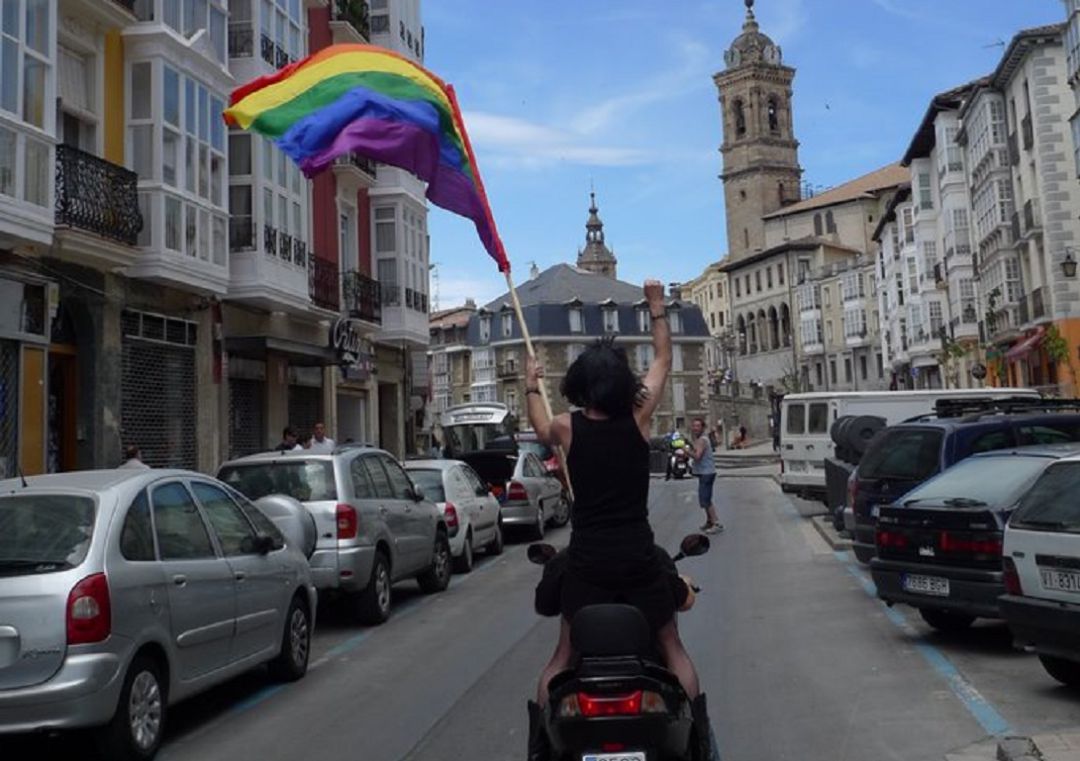 Una persona sostiene la bandera arcoíris Una persona sostiene la bandera arcoíris