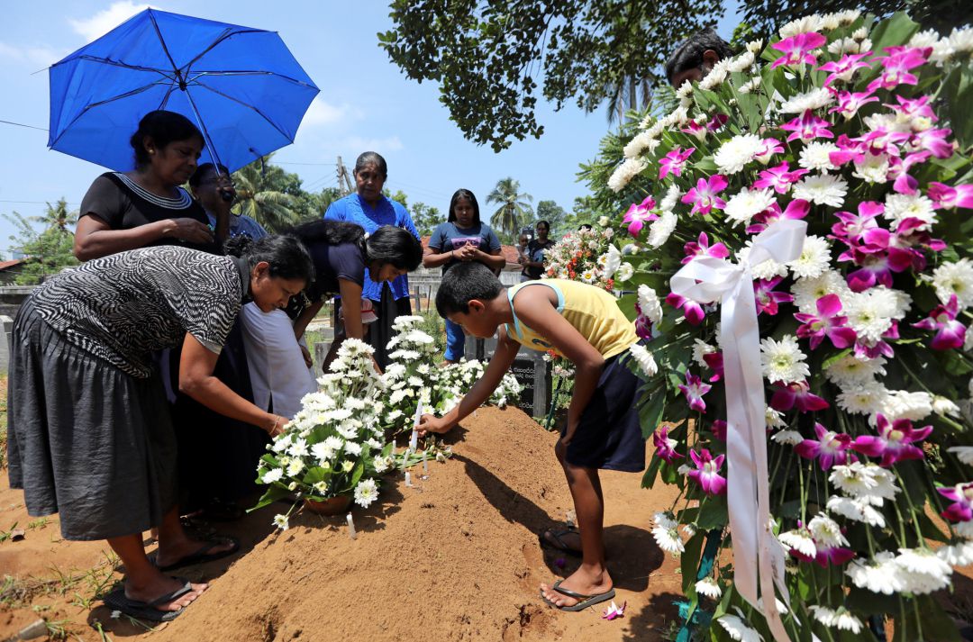 Una familia pone flores en una de las tumbas. Una familia pone flores en una de las tumbas.