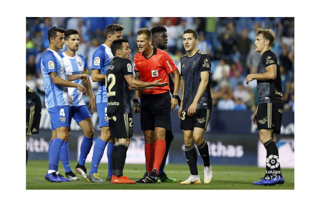 Jugadores del Oviedo y el Málaga protestan una decisión del colegiado. Jugadores del Oviedo y el Málaga protestan una decisión del colegiado.