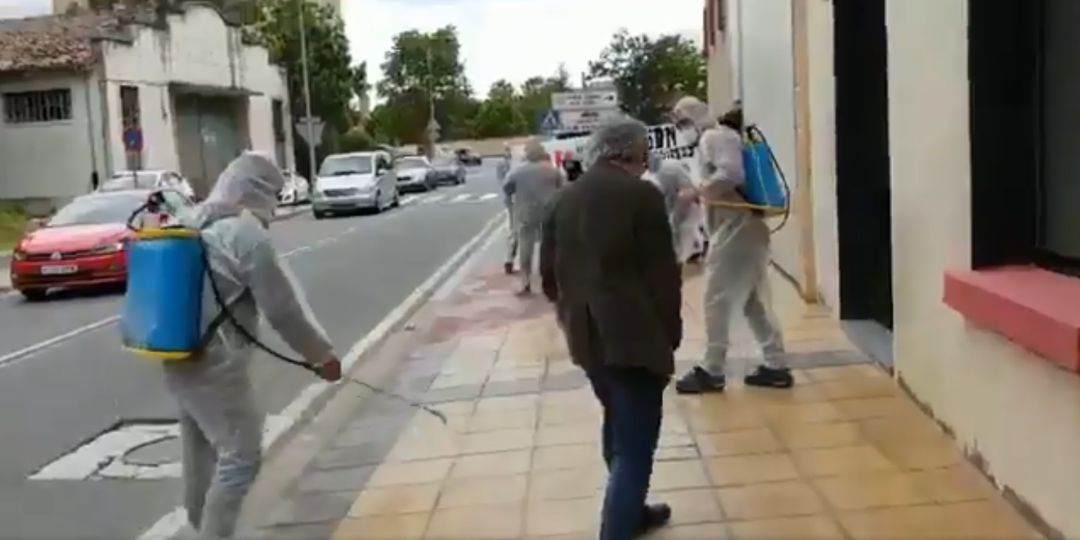 Personas con trajes de fumigar limpian la calle de Estella Personas con trajes de fumigar limpian la calle de Estella