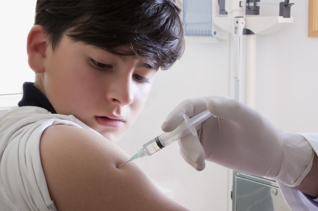 Médico vacunando a un adolescente Médico vacunando a un adolescente