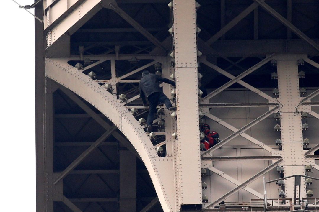 Un hombre escala la Torre Eiffel mientras varios bomberos tratan de detenerlo, este lunes en París (Francia Un hombre escala la Torre Eiffel mientras varios bomberos tratan de detenerlo, este lunes en París (Francia