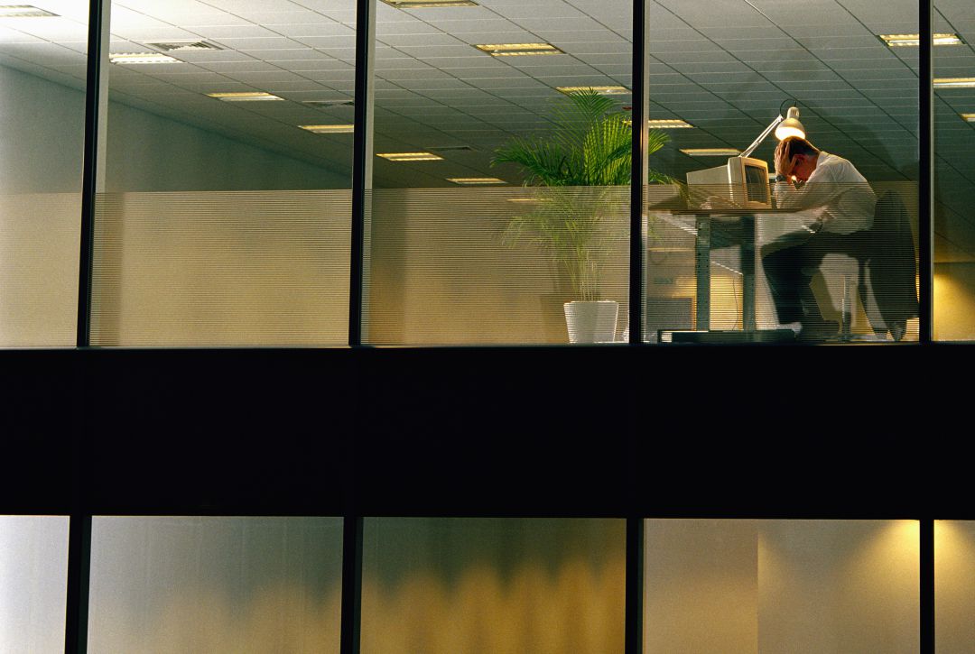 Un trabajador apura las últimas horas del día en la oficina Un trabajador apura las últimas horas del día en la oficina