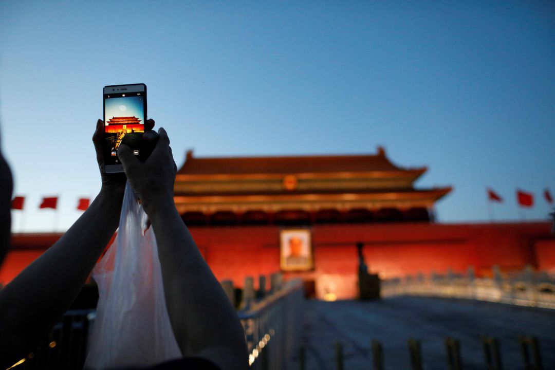 Una mujer fotografía la Puerta de Tiananmen en Pekín con su móvil Una mujer fotografía la Puerta de Tiananmen en Pekín con su móvil