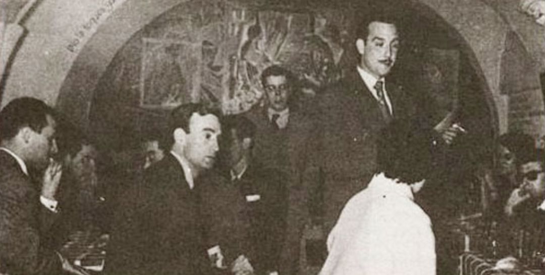 Tomás Ruiz, de pie y con bigote, en una de las tertulias literarias del local Cuevas de Sésamo en Madrid. Tomás Ruiz, de pie y con bigote, en una de las tertulias literarias del local Cuevas de Sésamo en Madrid.