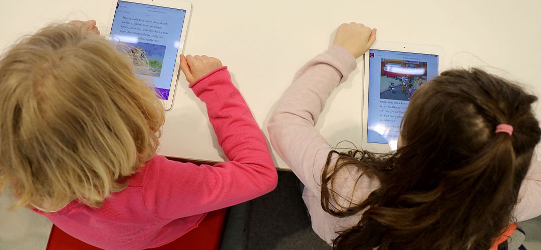 Dos niños manejan un iPad Dos niños manejan un iPad