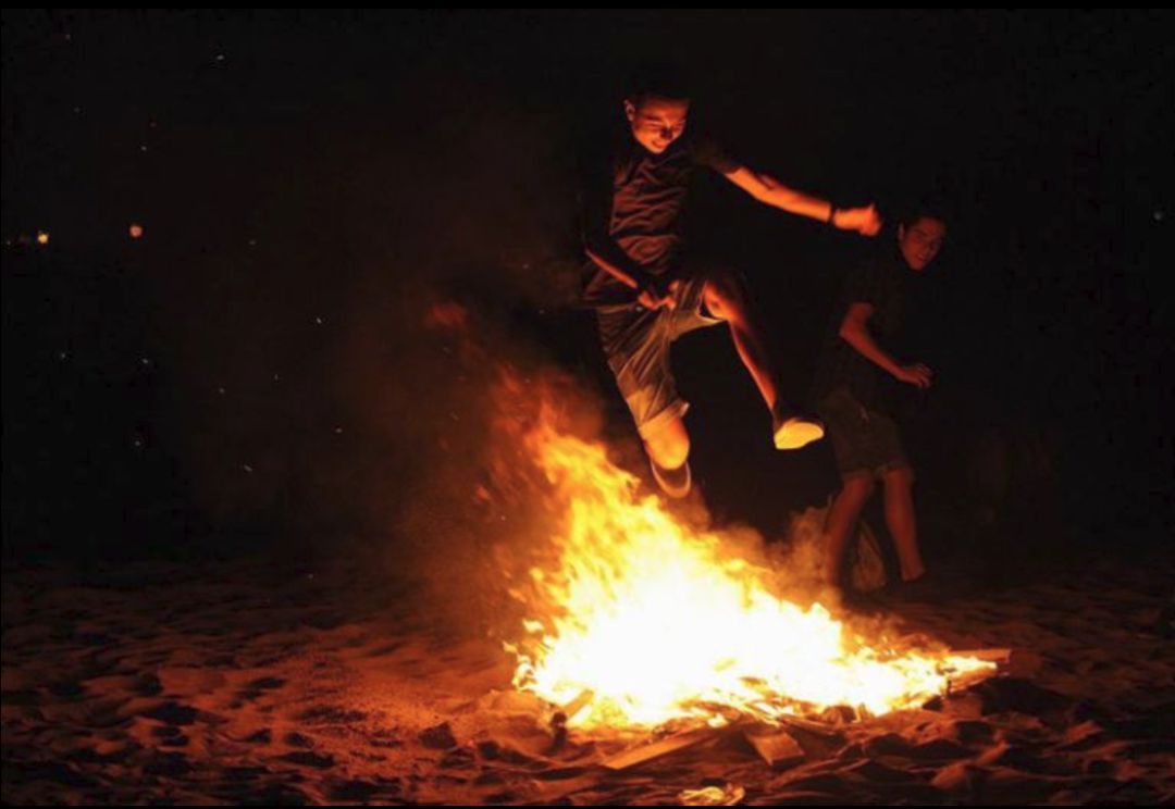 Joven saltando una hoguera en las playas de Castellón Joven saltando una hoguera en las playas de Castellón