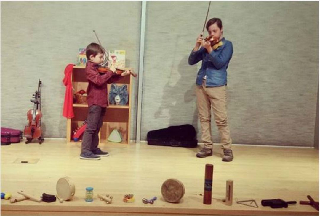 Dos niños disfrutando con sus violines Dos niños disfrutando con sus violines