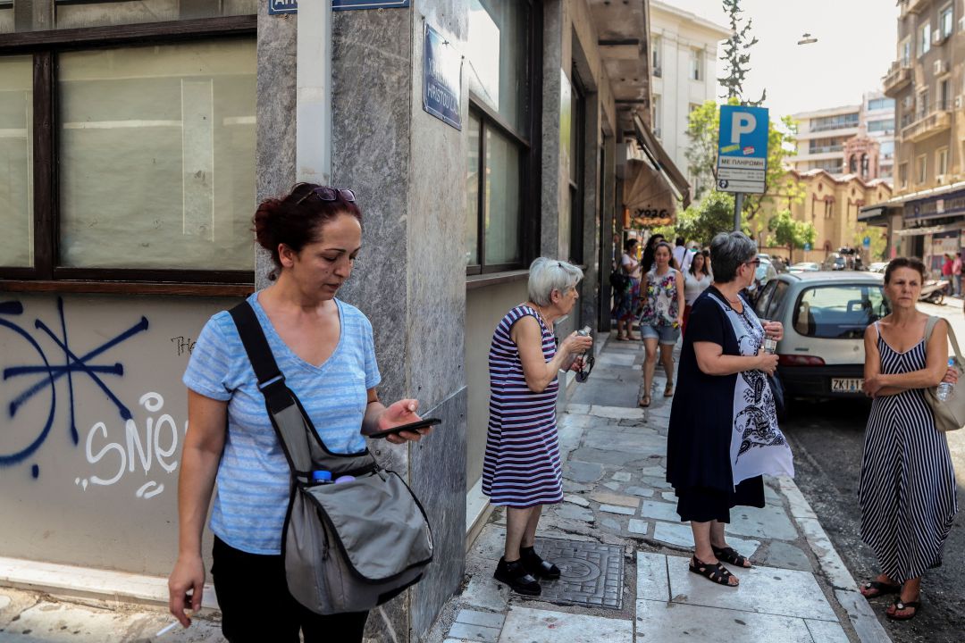 Varias personas esperan junto a un edificio del centro de Atenas tras el terremoto de este viernes. Varias personas esperan junto a un edificio del centro de Atenas tras el terremoto de este viernes.