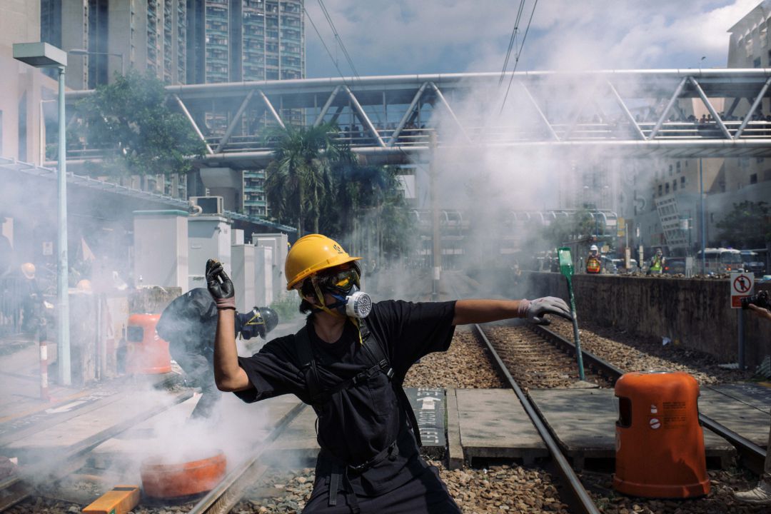 Uno de los manifestantes arroja piedras contra la policía frente a la comisaría de Tin Shui Wai, este lunes. Uno de los manifestantes arroja piedras contra la policía frente a la comisaría de Tin Shui Wai, este lunes.