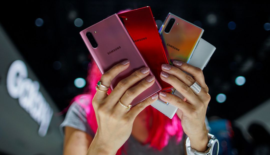 Una mujer sujeta varios teléfonos móviles de la marca Samsung. Una mujer sujeta varios teléfonos móviles de la marca Samsung.