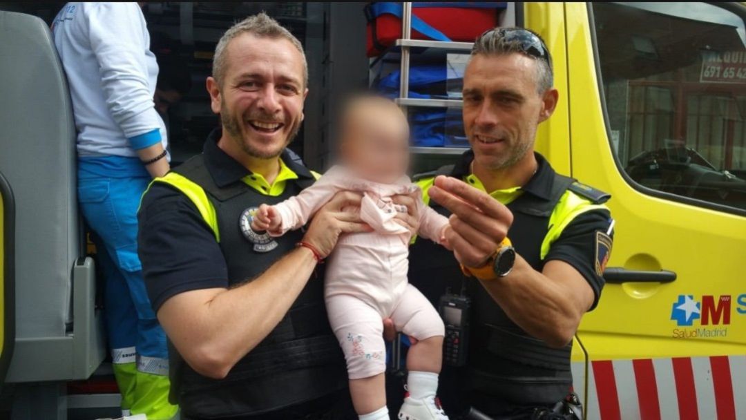Los dos agentes de la Policía Local de Alcalá de Henares posan con la bebé a la que han conseguido salvar la vida. Los dos agentes de la Policía Local de Alcalá de Henares posan con la bebé a la que han conseguido salvar la vida.