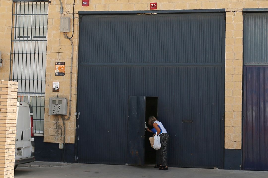 Una persona se asoma en la puerta de la fábrica de la empresa Magrudis en Sevilla Una persona se asoma en la puerta de la fábrica de la empresa Magrudis en Sevilla