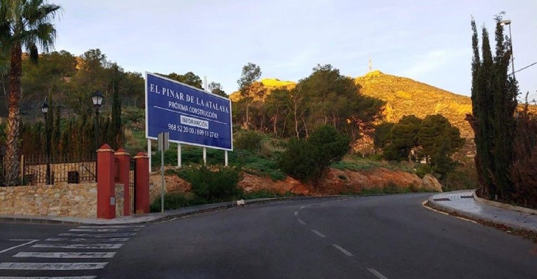 La pinada susceptible de ser urbanizada, con un cartel promocional de las obras La pinada susceptible de ser urbanizada, con un cartel promocional de las obras